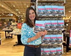 Stacy Rubis poses in front of a display of her new novel at a bookstore.